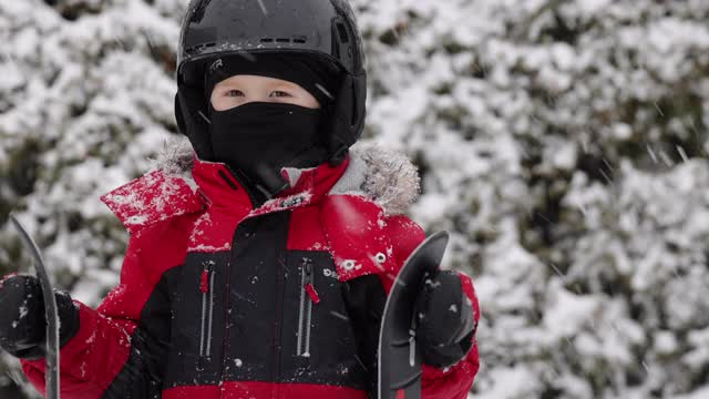 小男孩戴着运动头盔和在冬天户外滑雪的特写视频素材