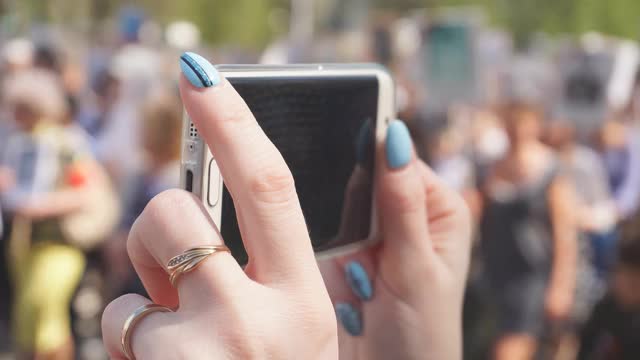 一个女人的手拿着手机的特写，用智能手机拍视频视频素材
