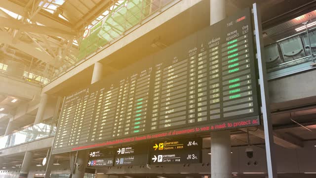 乘客在素万那普机场到达板的视频，航班信息实时更新。目的地，航班状态，登机口信息在屏幕上变化。视频下载