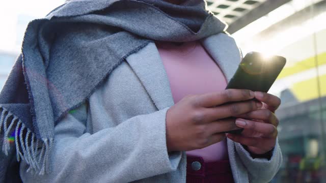 一个女人在电车站用手机发短信的特写视频下载