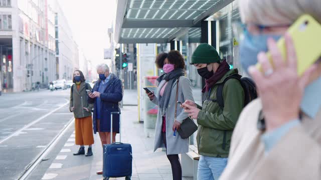 一群戴口罩的人在电车站视频素材
