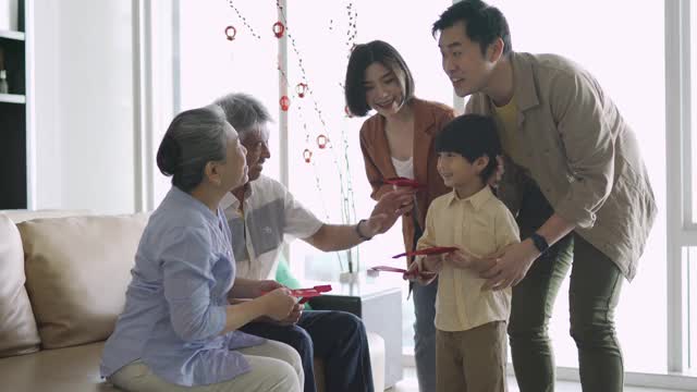 春节期间，亚洲华人的祖父母在家给孙子发红包视频素材