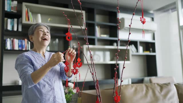 亚洲华人奶奶在庆祝春节期间装饰他们的家视频素材