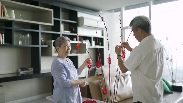 亚洲华人祖父母在庆祝春节期间装饰他们的家视频素材