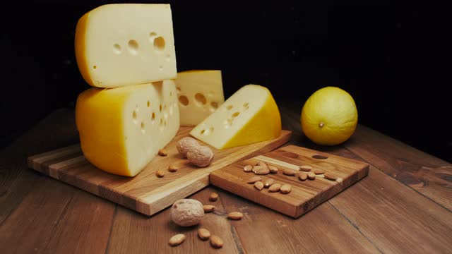 中等硬度的奶酪头，伊达豪达干酪放在木板上，加坚果和蜂蜜。幻灯片拍摄视频下载