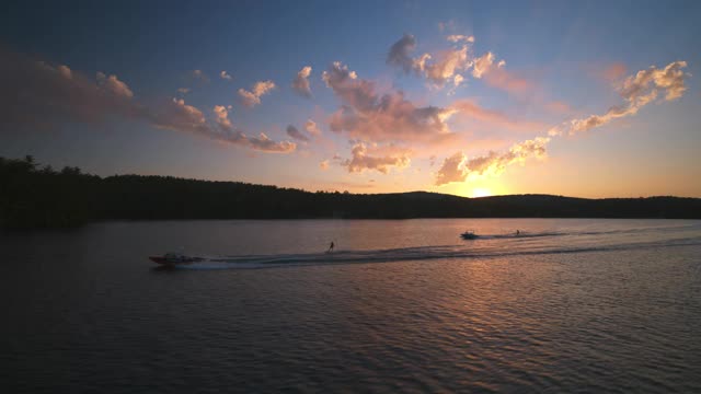 鸟瞰图两个水上滑雪者在一个美丽的湖上日落视频下载