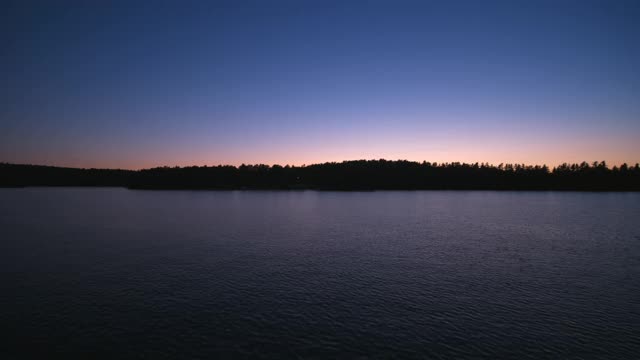 日落时分，一艘小船和水上滑板者的无人机视角视频素材