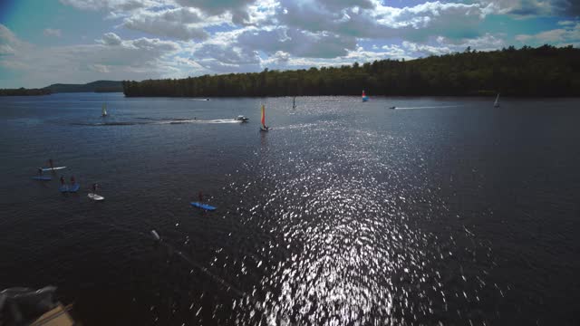 鸟瞰帆船和摩托艇在一个阳光明媚的日子在湖上视频素材