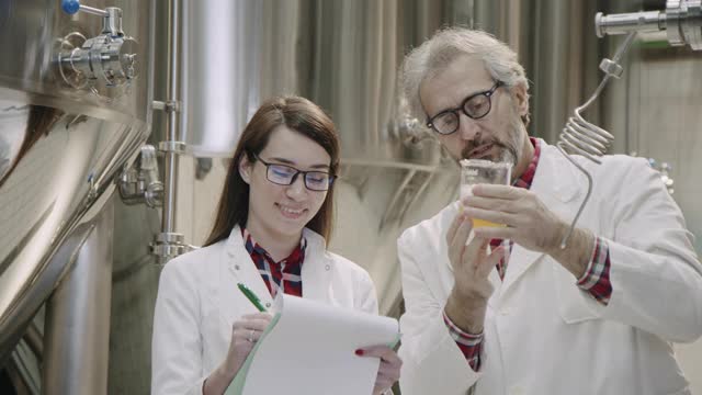 在一家啤酒厂，一组员工在检查酿酒厂生产过程中的酒罐视频下载