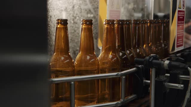啤酒厂自动机器上的瓶子视频下载