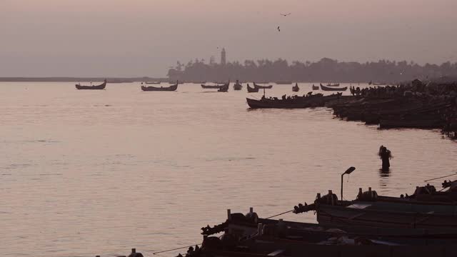 一个渔民投掷传统渔网的剪影景观视图，卡皮尔海滩，瓦尔卡拉，印度视频素材