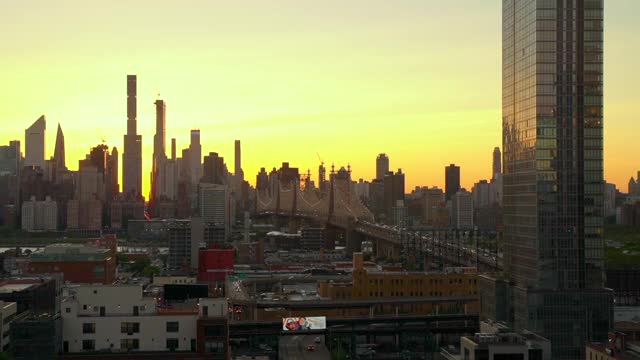 日落时分，在天空的映衬下，在城市建筑物之间的桥梁与交通的延时拍摄-纽约，纽约视频素材