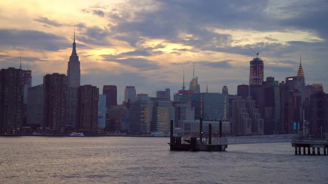 日落时分，城市中现代建筑对着天空拍摄的河流的延时拍摄——纽约，纽约视频素材
