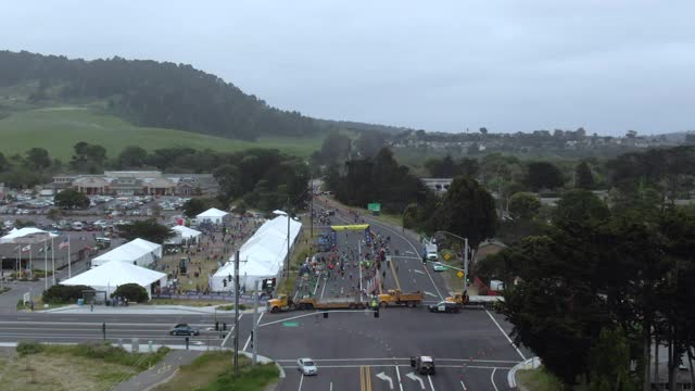 空中倾斜拍摄的人在街道上马拉松比赛，无人机飞在城市的道路上的天空-大苏尔，加利福尼亚视频下载