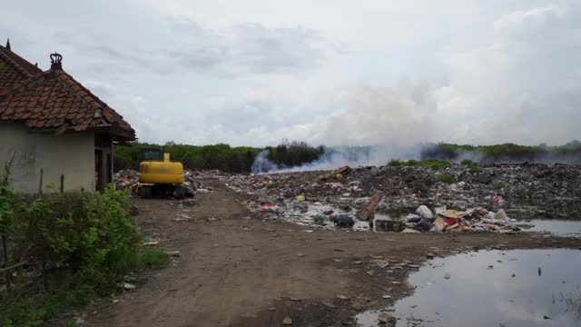 装满了冒烟的垃圾、雾蒙蒙的天空和腐烂的垃圾的水池——巴厘岛的努沙佩尼达和龙目岛视频素材