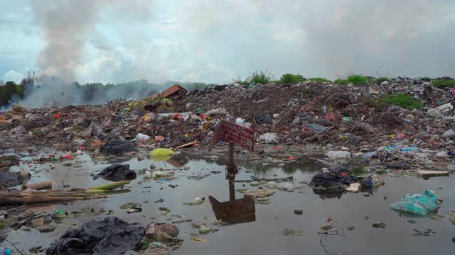 装满了冒烟的垃圾、雾蒙蒙的天空和腐烂的垃圾的水池——巴厘岛的努沙佩尼达和龙目岛视频素材