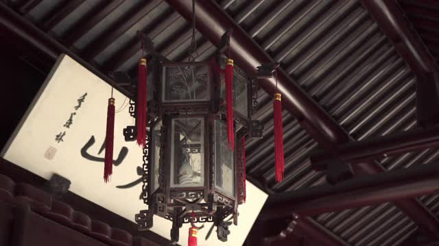 以“中国苏州”为背景，摇摄屋顶上挂着红色流苏的灯笼视频素材