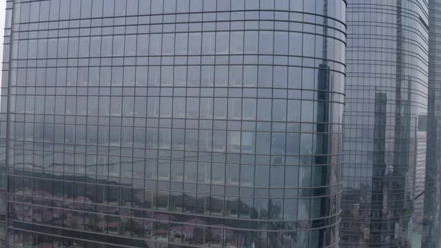 航拍现代玻璃建筑在城市与湖泊反射，无人机上升的办公楼在市中心-苏州，中国视频素材