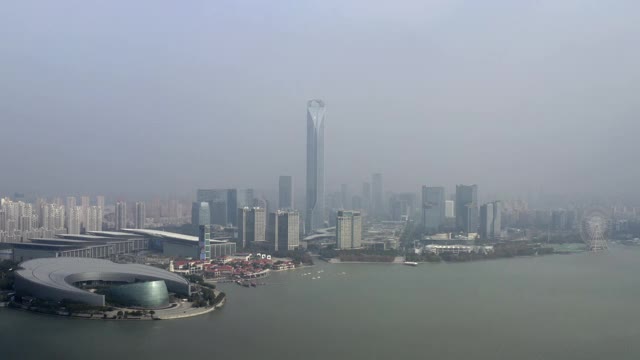 在阳光明媚的日子里，无人机在城市附近飞行，拍摄金鸡湖上的现代摩天大楼，中国苏州视频素材