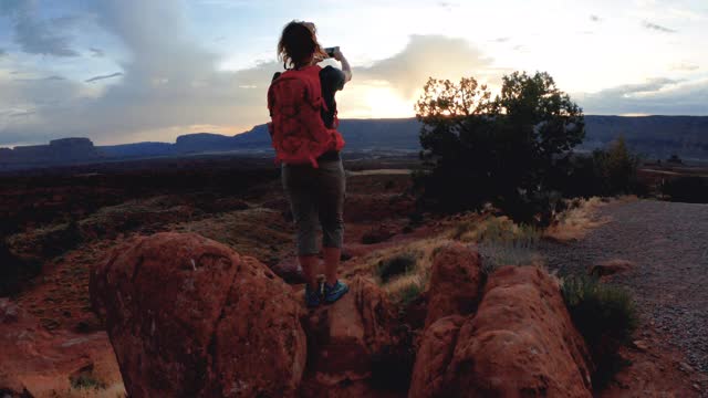 在美国西南部的沙漠冒险:女人徒步附近的峡谷地，摩押视频下载