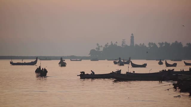 风景剪影渔民去捕鱼在他们的传统船，卡皮尔海滩，瓦尔卡拉，印度视频下载