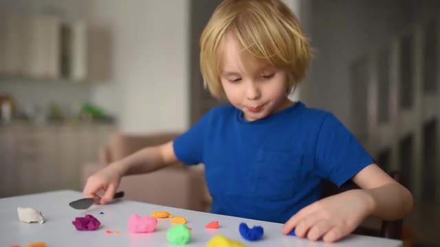小男孩在隔离期间在家玩面团。由橡皮泥制成的儿童造型。创意课程，远程学习，家庭教育，在线幼儿园。孩子们娱乐视频下载