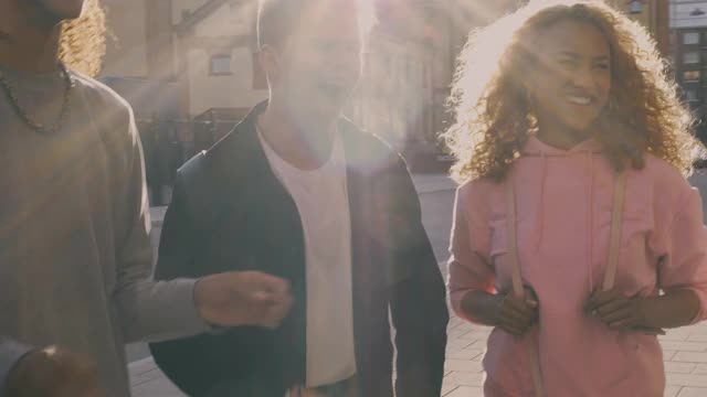 快乐的男性和女性朋友有乐趣在城市在阳光灿烂的一天视频素材