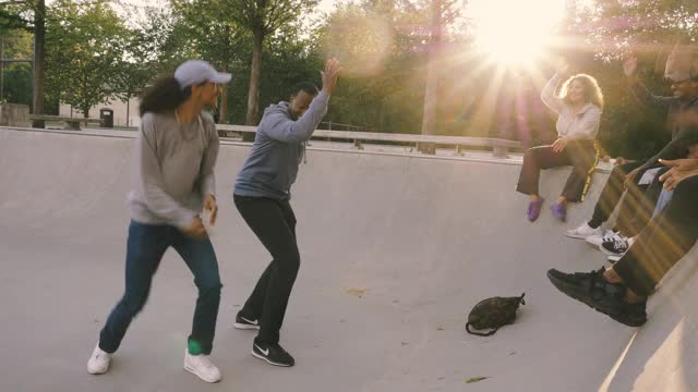 朋友们在滑板公园举手跳舞视频素材