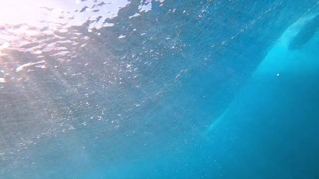 戏剧性的水下巨大的海浪滚动和破碎，与深蓝色的水和发光的泡沫和一个冲浪者漂浮在表面-瓦胡岛，夏威夷视频素材