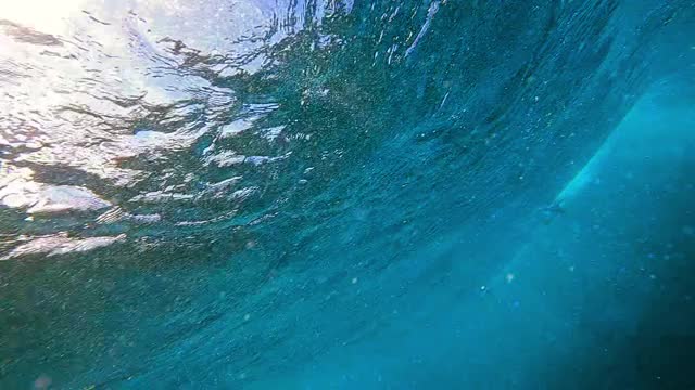 水下跟踪一个冲浪者，通过移动的水和反射的阳光艺术扭曲，他移动在翻滚的波浪-瓦胡岛，夏威夷视频素材