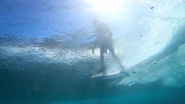 水下跟踪一个冲浪者的剪影骑在破浪，斑纹的阳光和泡沫上升到海面-瓦胡岛，夏威夷视频素材