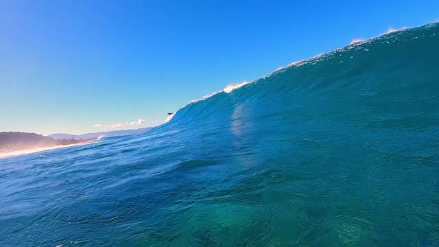 部分水下跟踪与一个冲浪者在远处，明亮的蓝色天空，和强大的撞击水-瓦胡岛，夏威夷视频素材