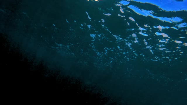 水下跟踪一个冲浪者，通过移动的水和反射的阳光艺术扭曲，他在水面上移动-瓦胡岛，夏威夷视频素材