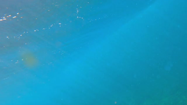 水下看冲浪板在破浪顶部飞行，阳光反射通过海洋表面-瓦胡岛，夏威夷视频素材