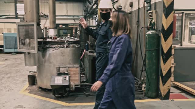 金属铸造同事在铸造厂散步视频素材