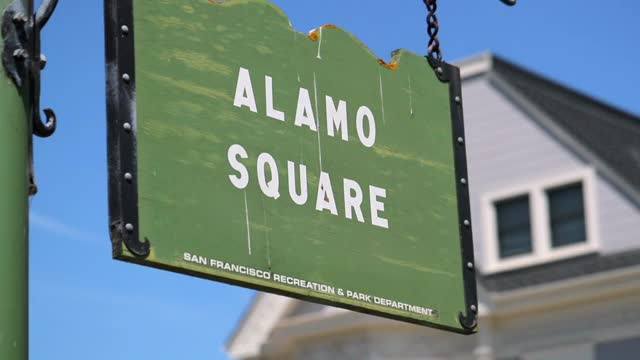低角度慢动作拍摄的阿拉莫广场的标志挂在城市在阳光明媚的一天-旧金山，加利福尼亚视频素材