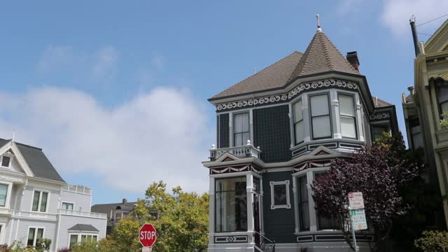 慢动作平移拍摄的房子和道路标志在城市对天空晴朗的一天-旧金山，加利福尼亚视频素材