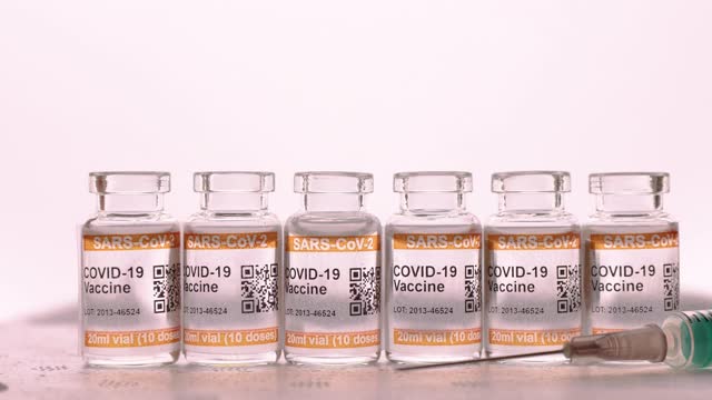 低温泡沫聚苯乙烯包装，顶部装有一套COVID-19疫苗瓶。标记SARS-CoV-2对抗冠状病毒。手戴防护手套拿注射器视频素材