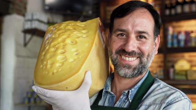 骄傲的男店主展示大块奶酪视频素材