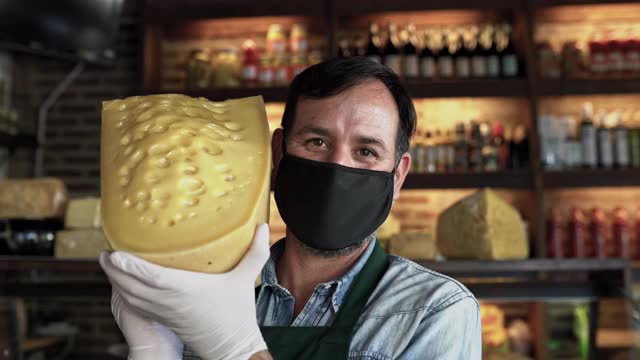 在COVID-19发生时，店主拿着大块奶酪视频素材
