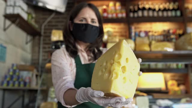 店主在COVID-19时期展示一块奶酪视频素材