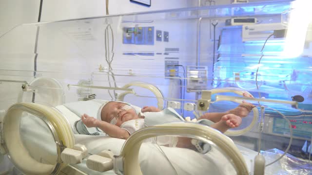 美丽的新生儿在新生儿重症监护室的保育箱里哭泣视频素材