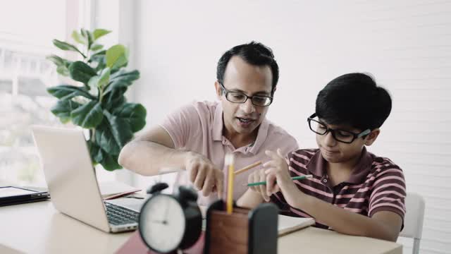 亚洲男孩做家庭作业，在他的父亲的帮助下。视频素材