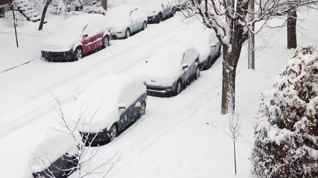 在暴风雪期间停在蒙特利尔罗斯蒙特地区住宅区街道上的汽车的高架视图视频素材