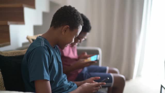 双胞胎兄弟在客厅玩手机游戏视频下载