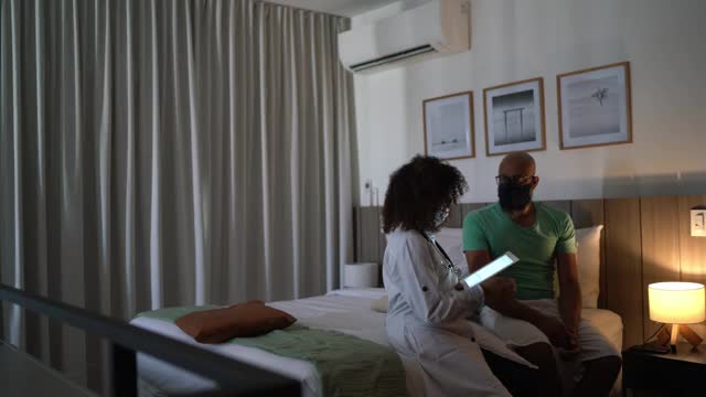 医生在病人的居家口罩中使用数字平板电脑视频素材