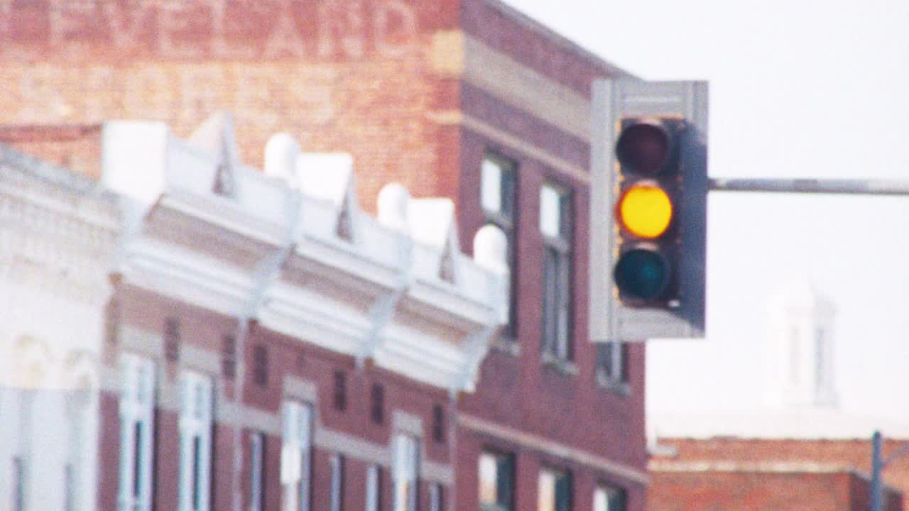 在中西部一个小乡村社区的市中心，一个孤独的交通灯从红到黄再到绿，背景是主街的砖立面。视频下载