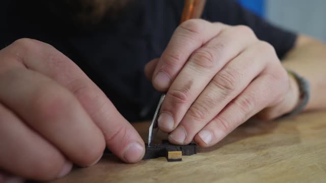 木雕师用刀切割正统的乌木十字架。工匠在木十字架上雕刻。视频下载