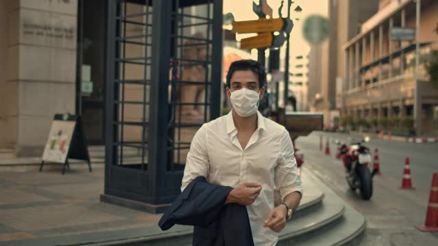 商人带着医用口罩穿过城市街道，特写视频素材