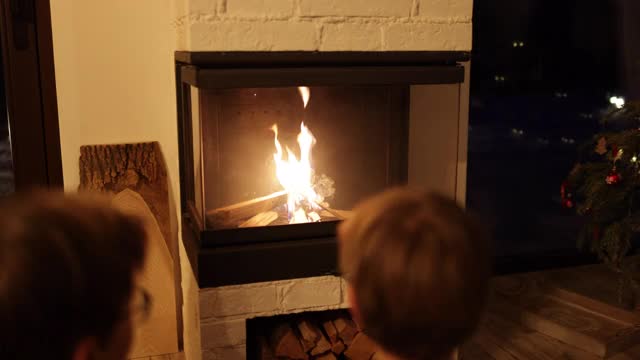 三个孩子坐在壁炉旁视频素材